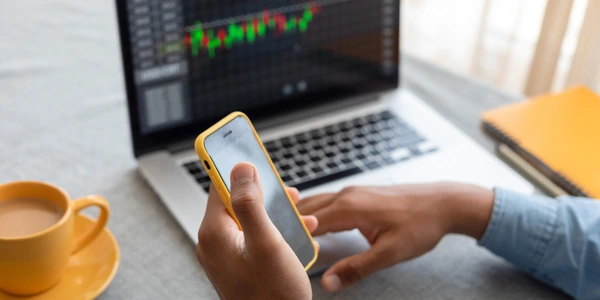 Phone and laptop displaying investment app